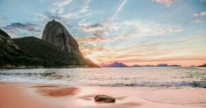 Le coucher de soleil sur une plage a Rio de Janeiro au Brésil avec une montage pointu en arrière plan