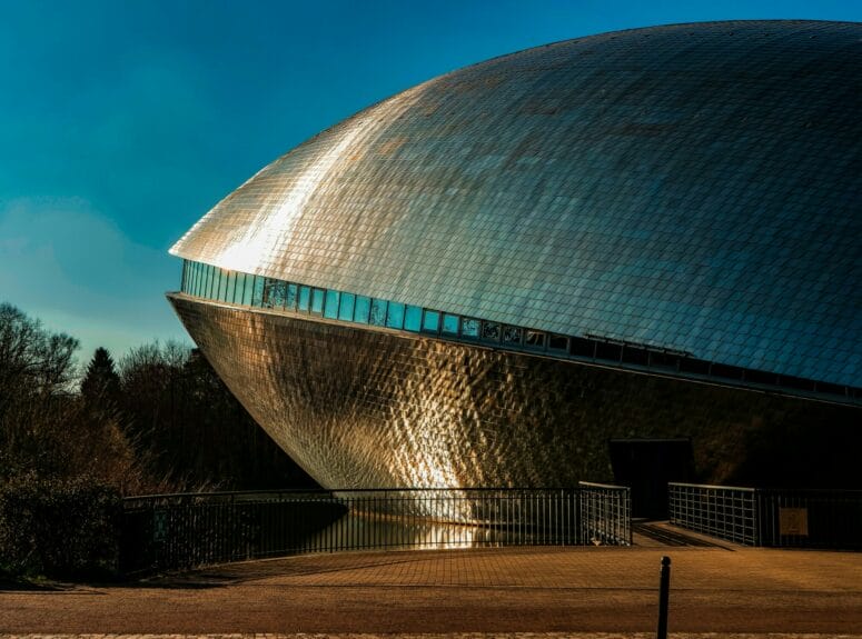 The large egg-shaped metal modern building of the Universum Bremen with the sun beaming on it