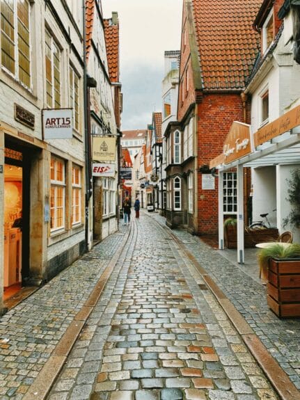 Brown and white buildings on a narrow cobblestoned street of Schnoorviertel in Bremen