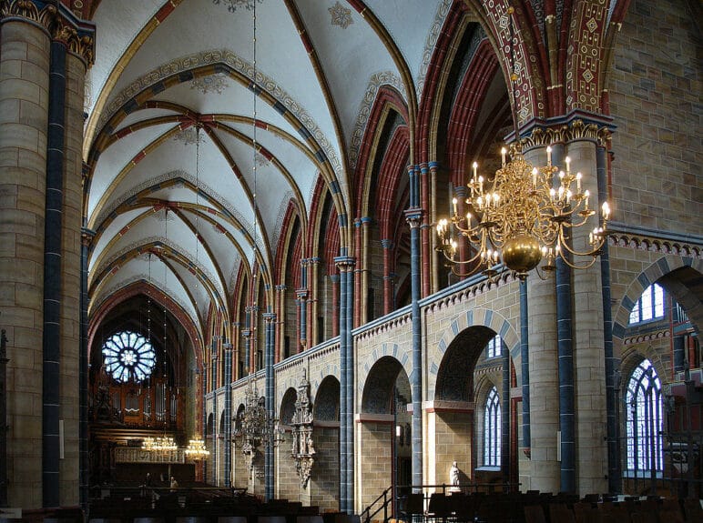 St. Peter’s Cathedral interior with chandeliers hanging from the white painted ceiling in Bremen, Germany.