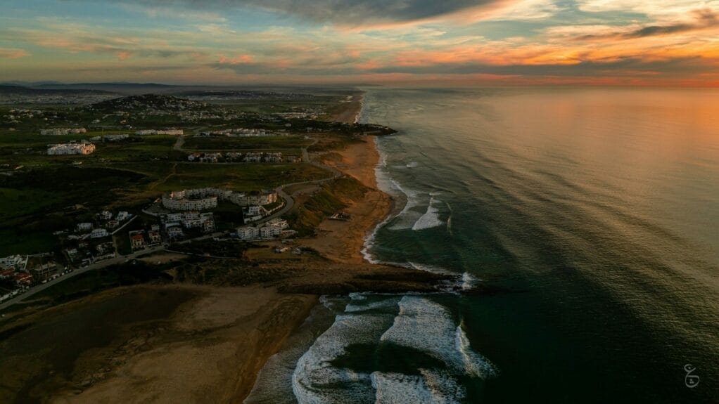 An aerial beach of Achakkar beach and ocean in Morocco at sunset.