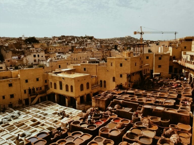 Vue aérienne de la tannerie de Chouara au Maroc avec des bâtiments bruns en arrière-plan.