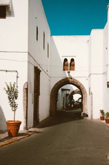 Bâtiment blanc avec une entrée en arc dans une rue de Casablanca, au Maroc.