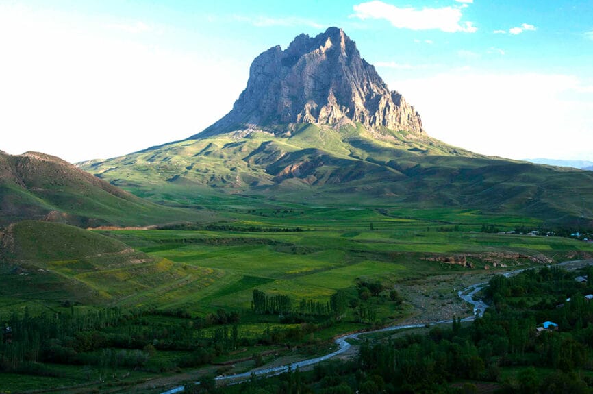 A tall, rocky, and rugged mountain towering over a landscape in Azerbaijan.