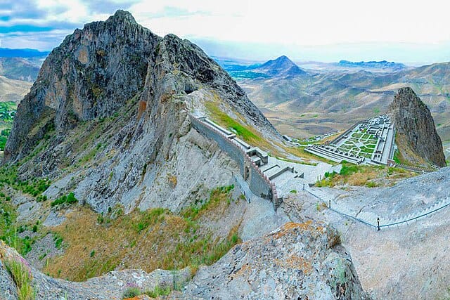 A fortress on top of a mountain with a huge mountain range in the background in Azerbaijan.