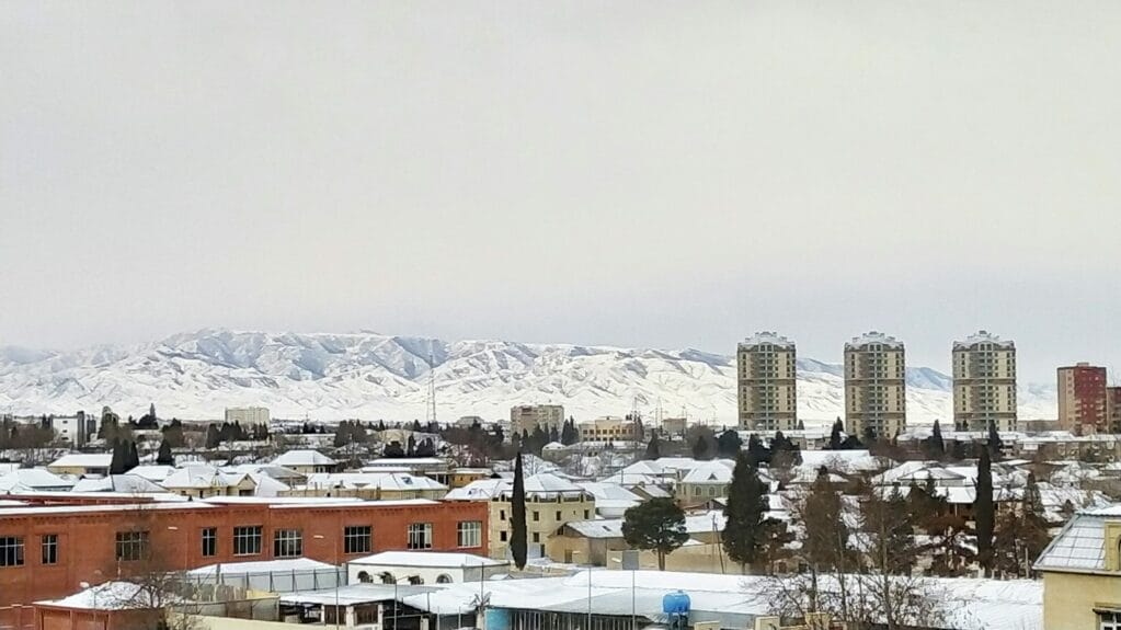 City view of Ganja covered in snow with mountains in the background in Ganja, Azerbaijan.