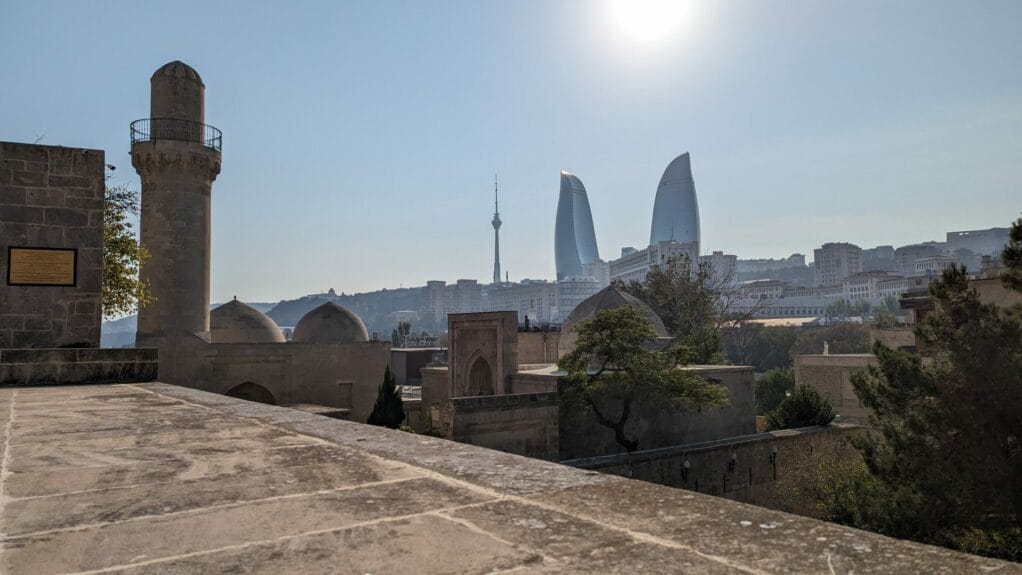 A group of skyscrapers shaped like a flame with buildings in the background in Baku, Azerbaijan.