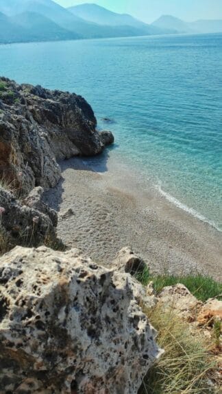 Qeparo Beach, Albania surrounded by rock formations and crystal clear waters.