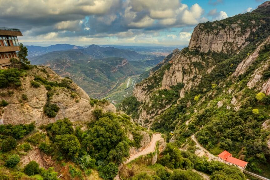 Tree-filled Montserrat Valley with mountains in the background.