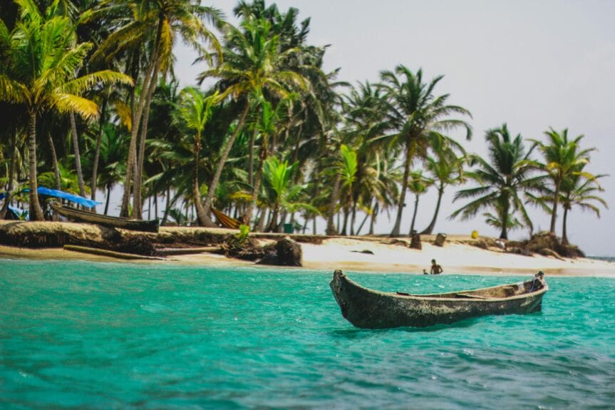 A canoe on a body of water on a beach in San Blas Islands, Panama