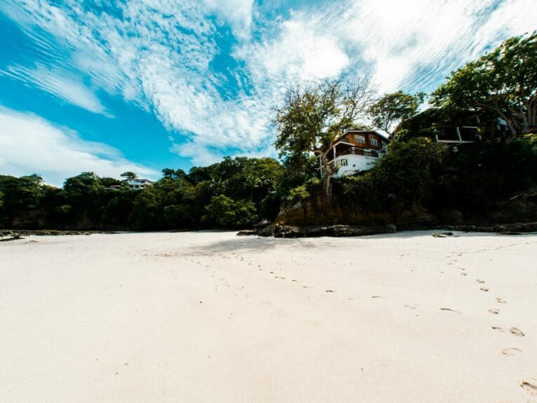 A white sandy beach with a house on top of it in Isla Contadora, Panama