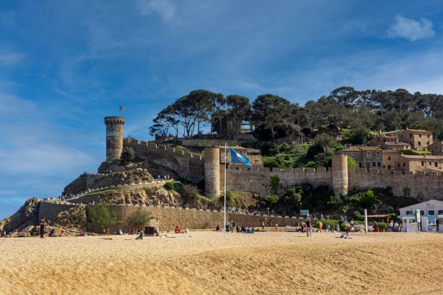 A view of Tossa de Mar’s medieval walls by the beach in Spain.