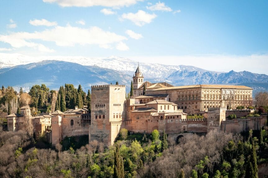 Vue aérienne du Palais de l'Alhambra à Granada, Espagne, sous un ciel bleu et des montagnes en arrière-plan.